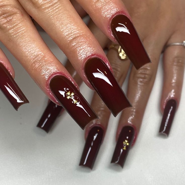 Chic Glossy Burgundy Nails with Elegant Gold Accents for a Glamorous Aesthetic