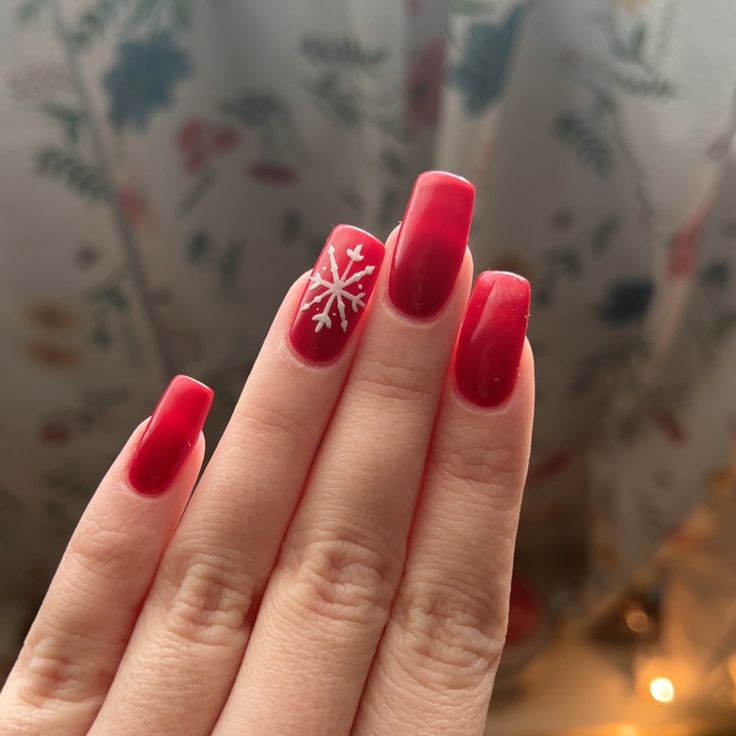 Elegant Red Nails with Glossy Finish and Festive Snowflake Accent Design.