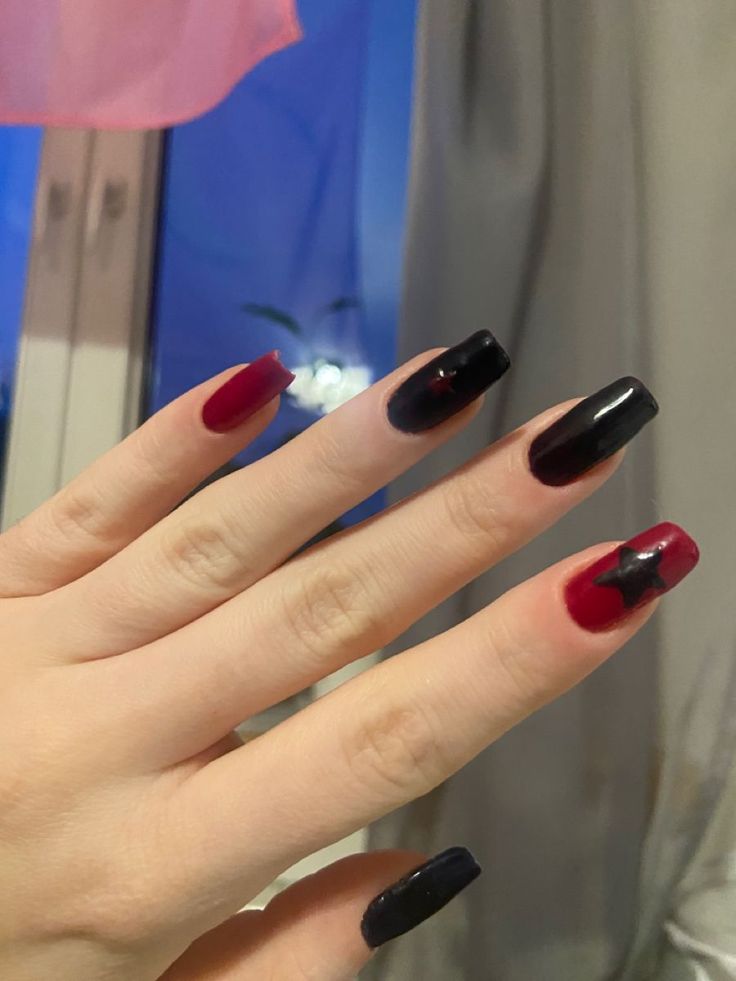 Edgy Bold Nail Art: Striking Black and Burgundy Design with Glossy Accents and Star Detail.