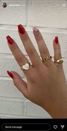 Striking Bold Red Nails with Elegant Accent Design and Decorative Rings.