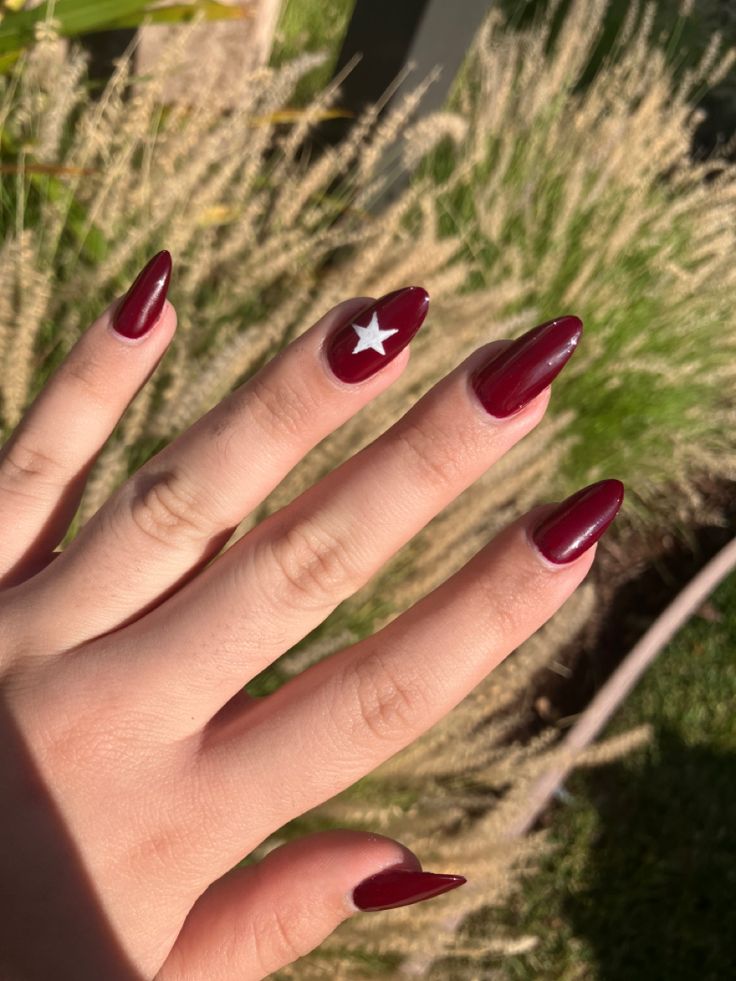 Sophisticated Burgundy Almond Nails with Playful Star Accent