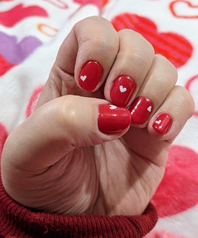 Playful Red Nail Design with White Hearts for Festive Celebrations.