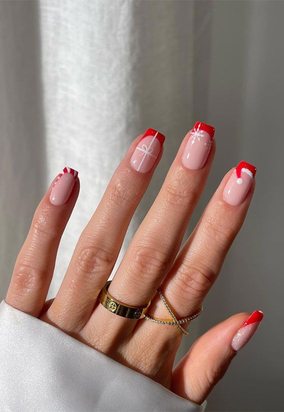 Chic Holiday Nail Design: Soft Pink Base with Bold Red Tips and Delicate White Accents.