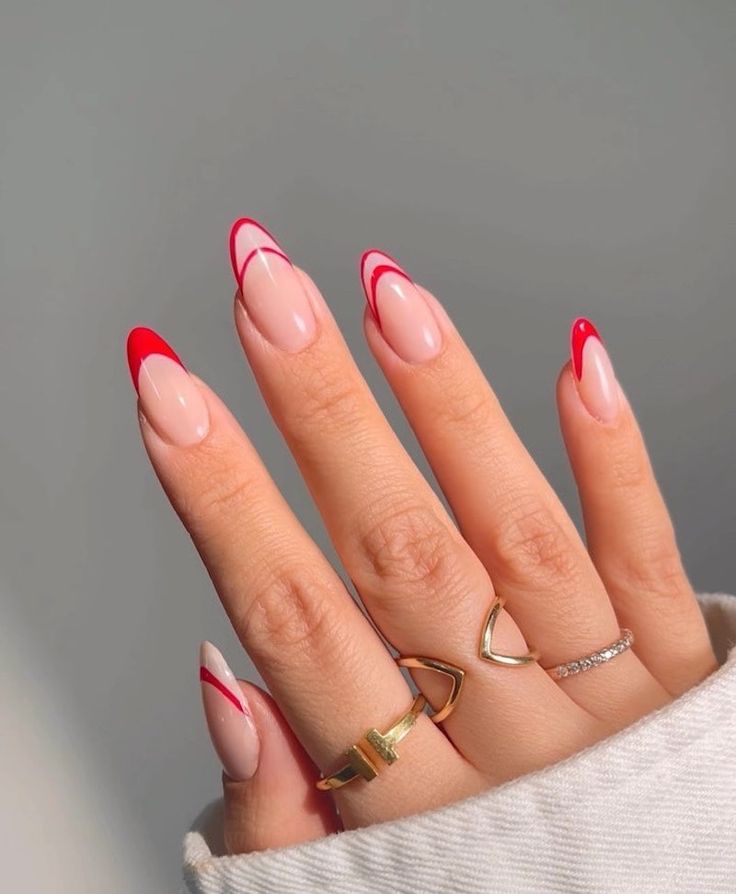 Chic Almond-Shaped Nails: Elegant Nude Base with Vibrant Red Tips and Minimalist Accents.