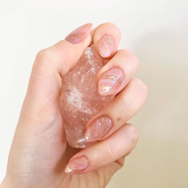 Elegant Almond-Shaped Soft Pink Acrylic Nails with Gold Accents and Glossy Finish, Highlighting Natural Beauty with Raw Crystal.