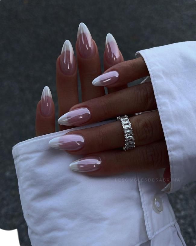 Elegant Almond-Shaped French Ombre Nails: A Sophisticated Nude-to-White Gradient with Glossy Finish.