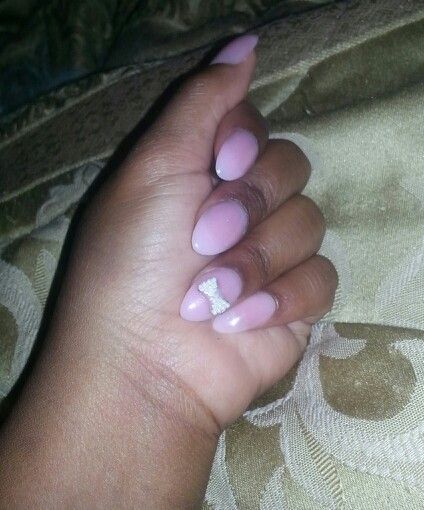 Sophisticated Pastel Pink Almond Nails with Whimsical Bow Accent.