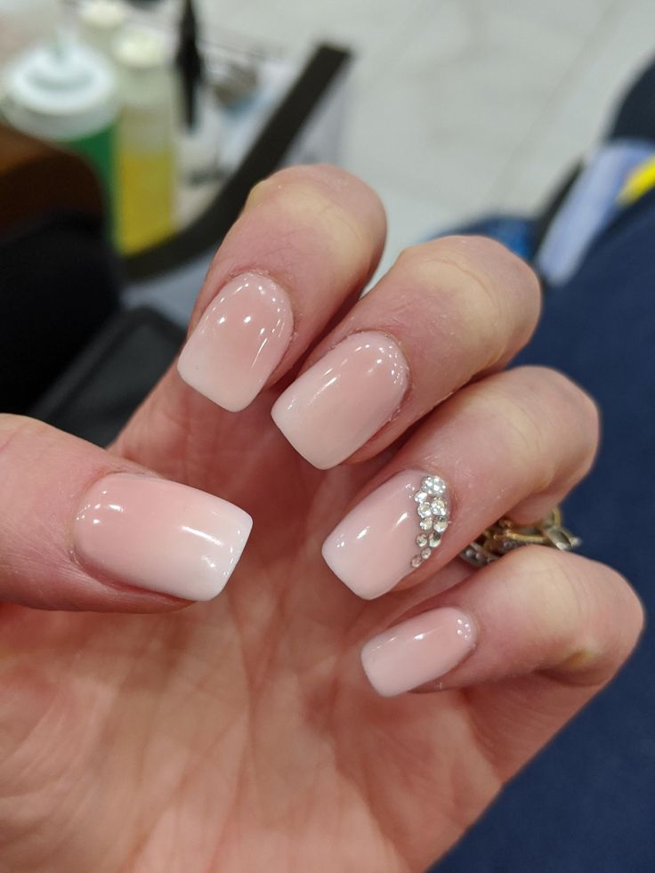 Chic Ombre Nail Design with Glossy White Tips and Rhinestone Accent.