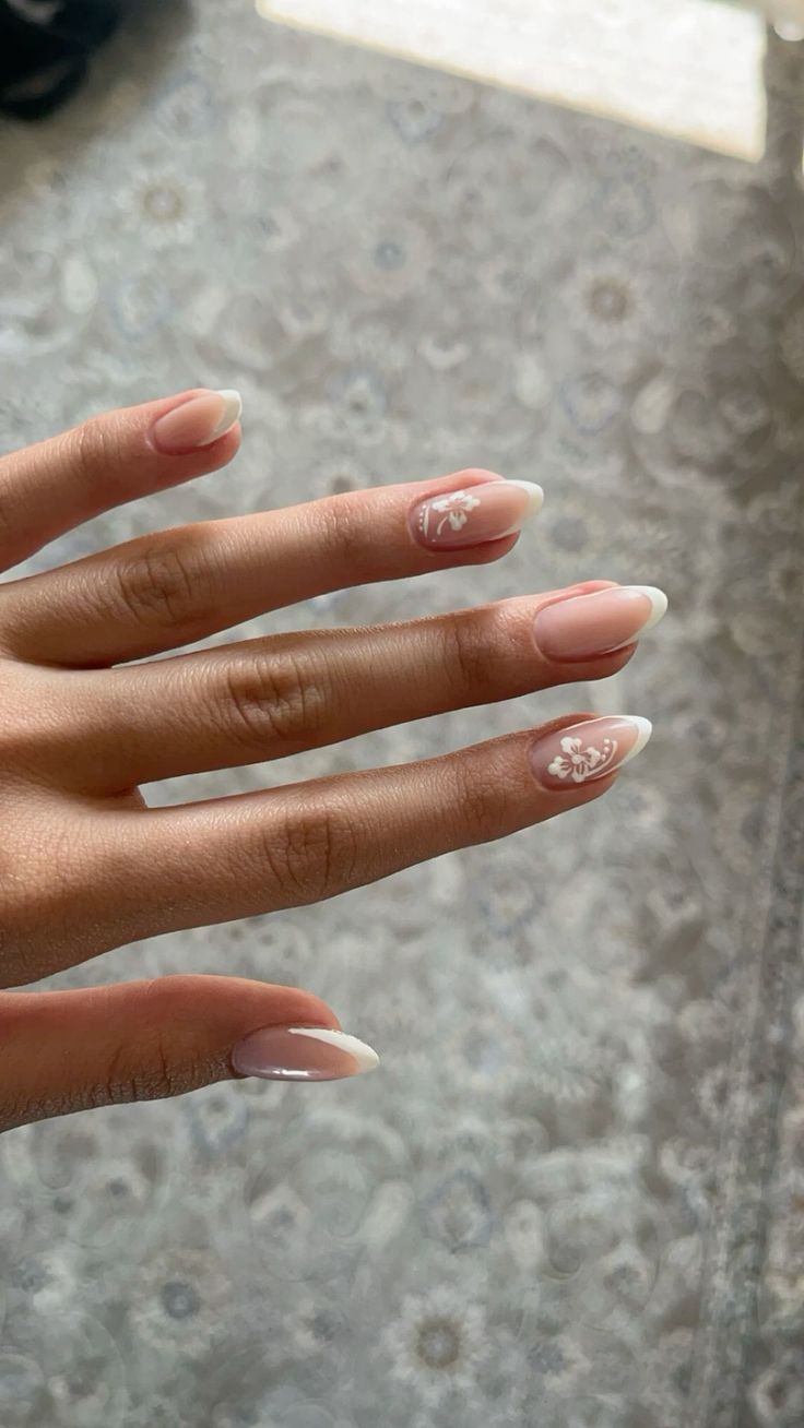 Sophisticated Ombre Nails with Floral Accents: A Stylish Blend of Soft Pink and Classic White.