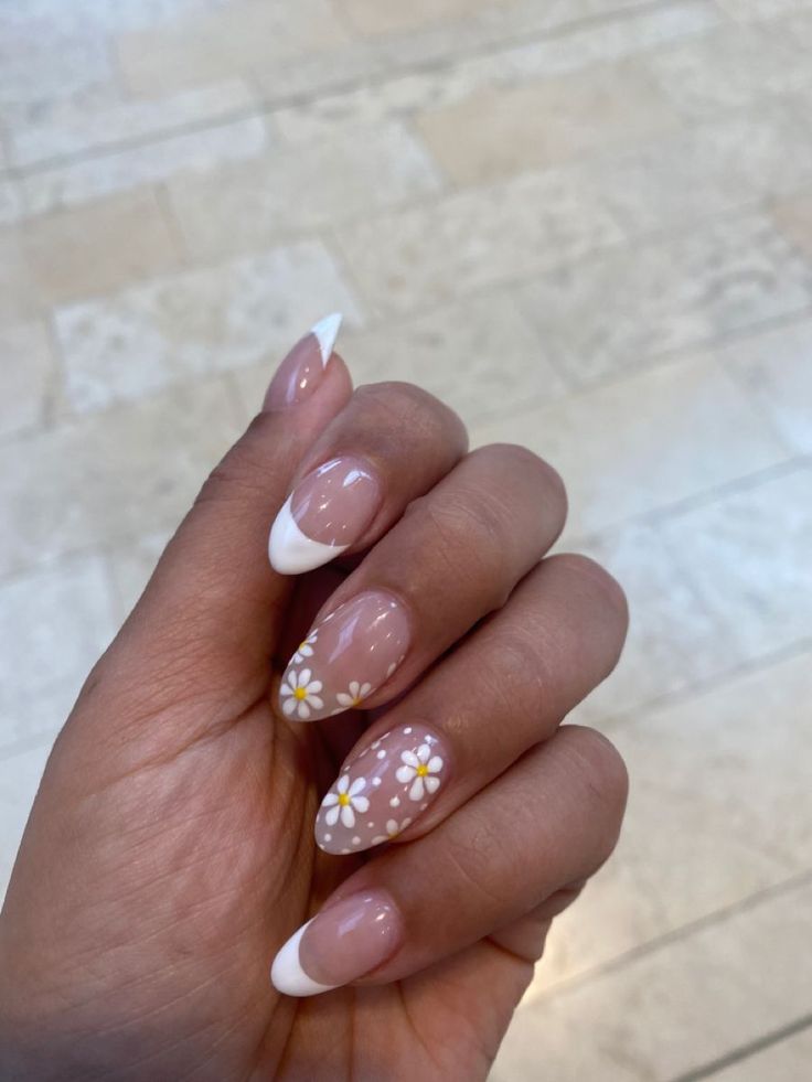 Sophisticated Nude Nail Design with Playful White French Tips and Floral Accents.