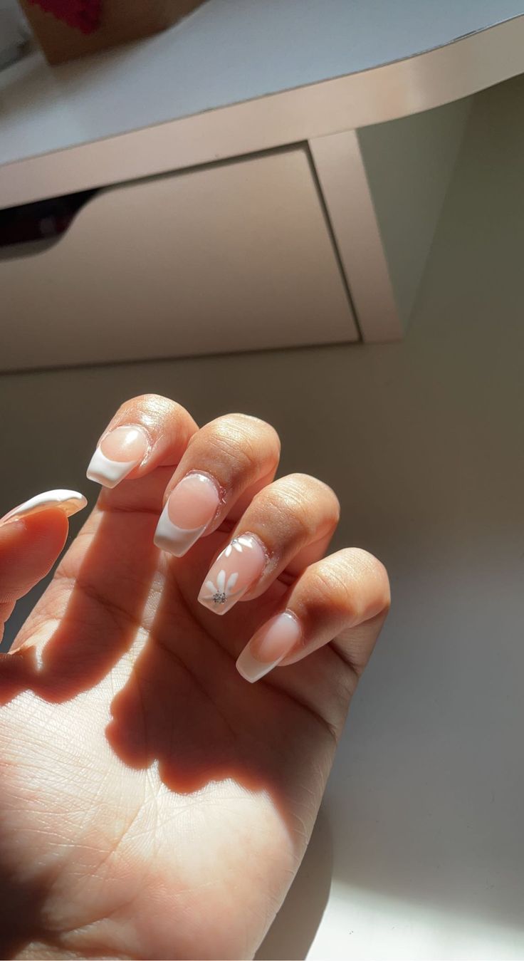 Chic French Manicure with Soft Pink Undertones and Floral Accents.