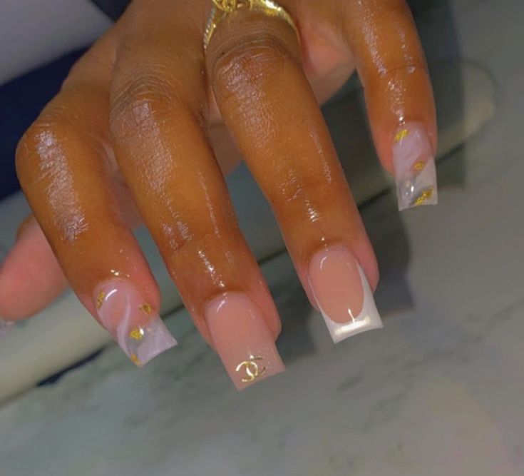 Chic Nude Nail Design with Glossy Tips and Marble Accents.