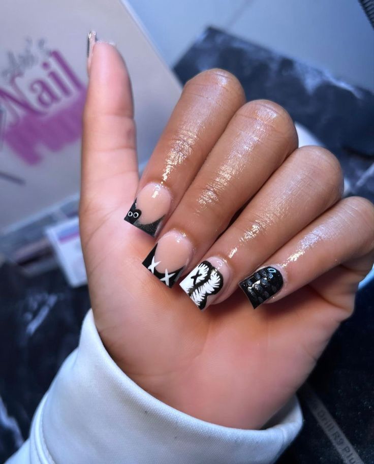 Dramatic Black-and-White Nail Art with Intricate Patterns and Glossy Finish.