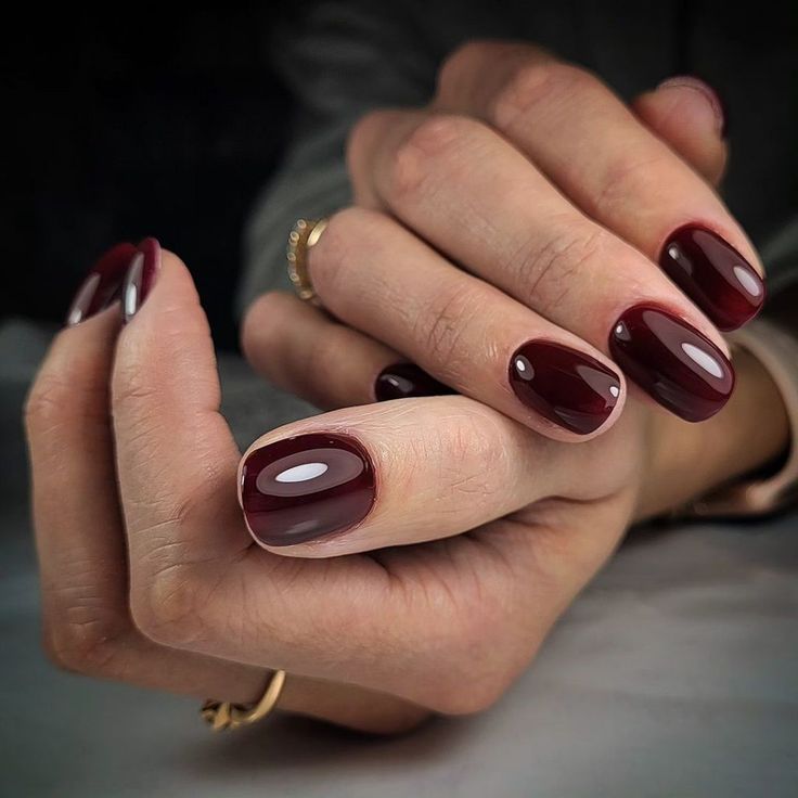 Sophisticated Oval Burgundy Nails with Glossy Finish and Modern Flair.