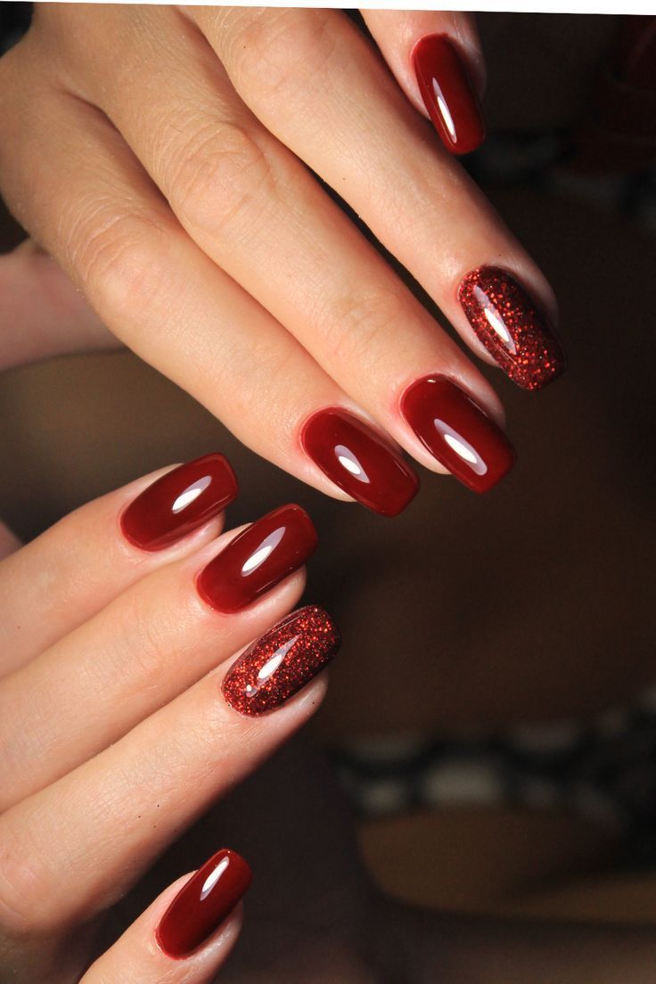 Vibrant Bold Red Nail Design with Glitter Accent: A Striking Blend of Glossy Elegance and Glamour.