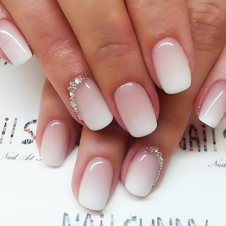 Chic Ombre Nails: Soft Pink to White Transition with Sparkling Accents