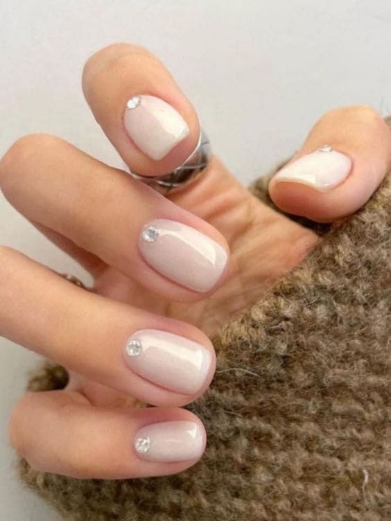 Chic Nude Nail Design with Shimmer and Rhinestones for Timeless Elegance.