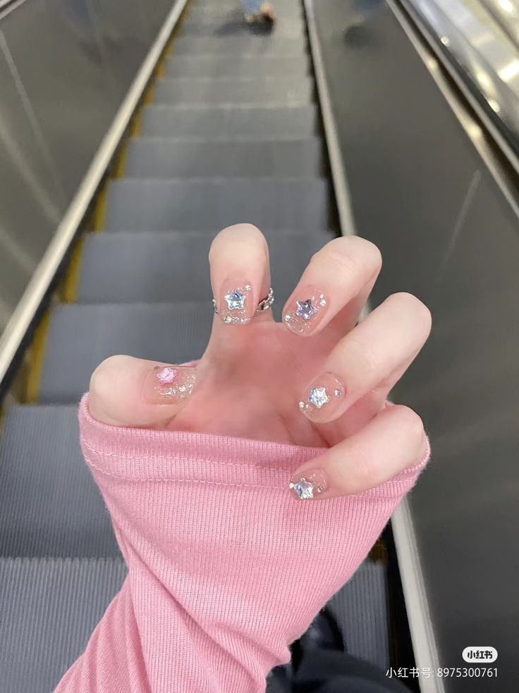 Whimsical Chic: Sparkling Pastel Nail Design with Iridescent Glitter and Gemstones.