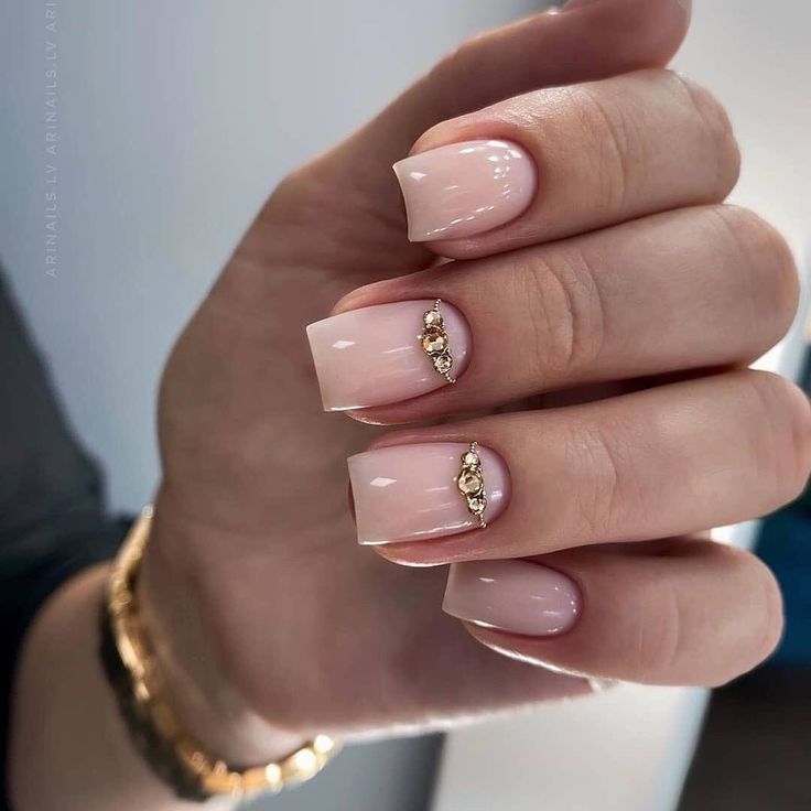 Chic Glossy Nude Nails with Gemstone Accents: A Modern Take on Elegant Simplicity.