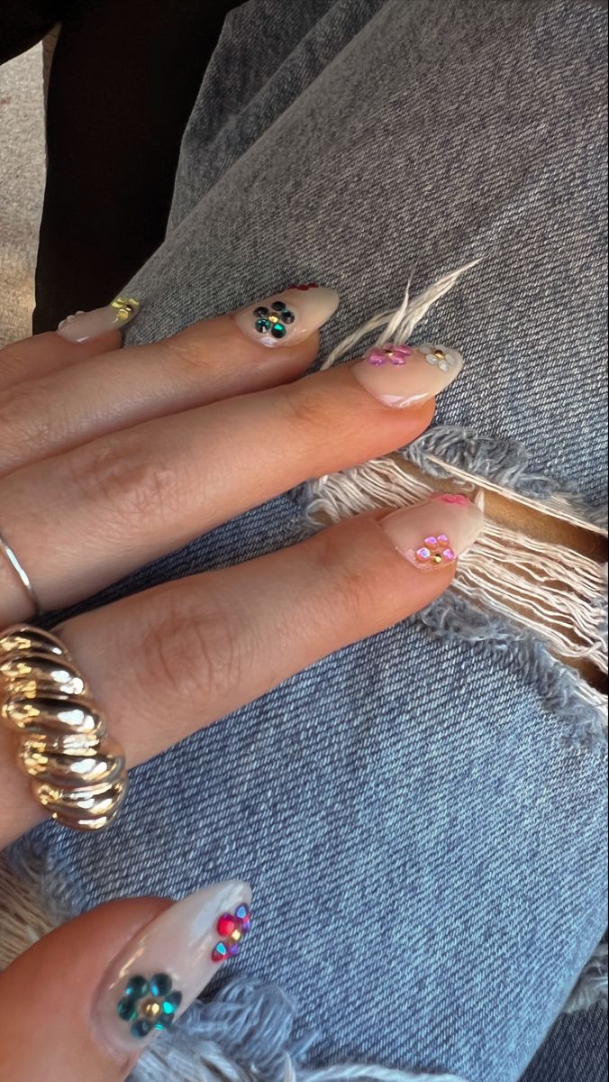 Chic Nude Nail Design with Playful Colorful Gem Accents.