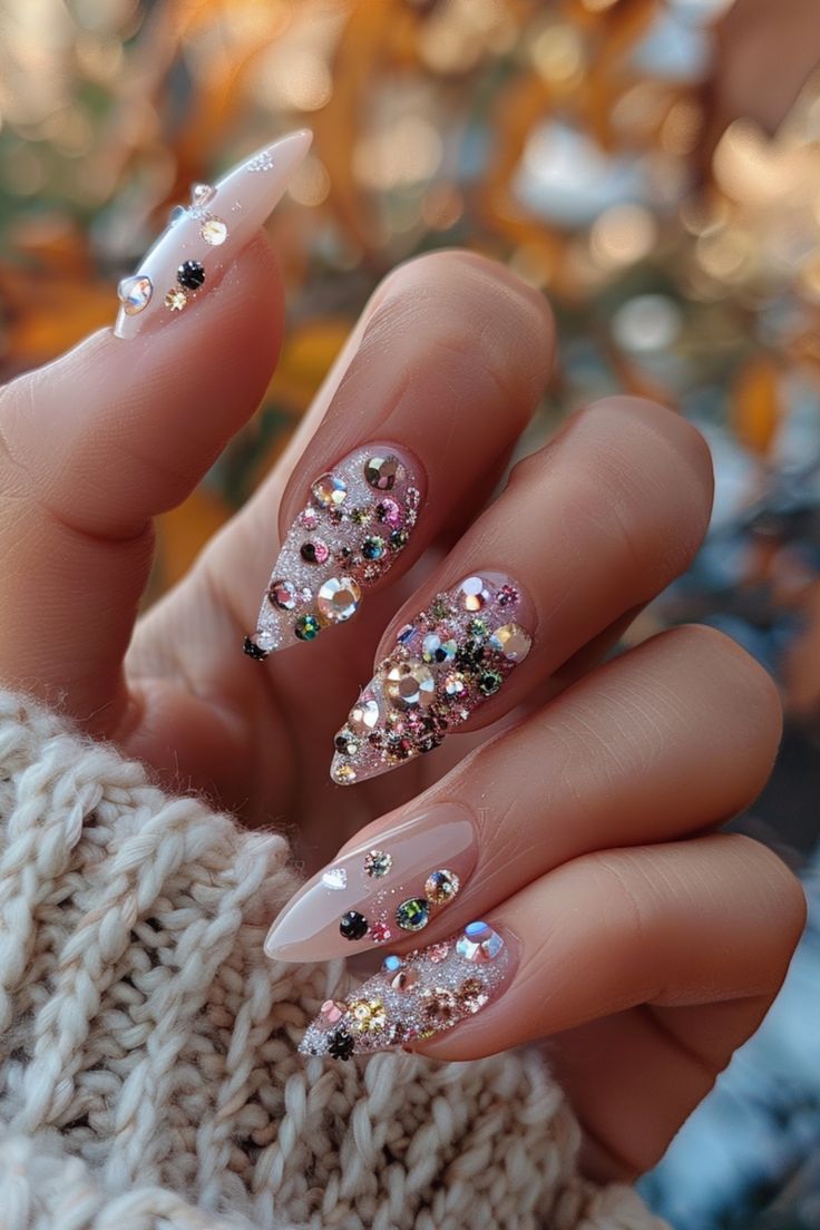 Glamorous Elongated Stiletto Nail Design with Colorful Gems and Shimmering Accents