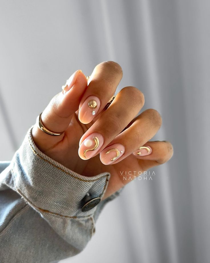 Sophisticated Elegant Nail Design with Soft Nude Base, Crescent Shapes, and Pearl Embellishments.