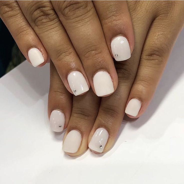 Sophisticated Elegant Nude Nail Design with Subtle Shine and Minimalist Gemstone Accents.