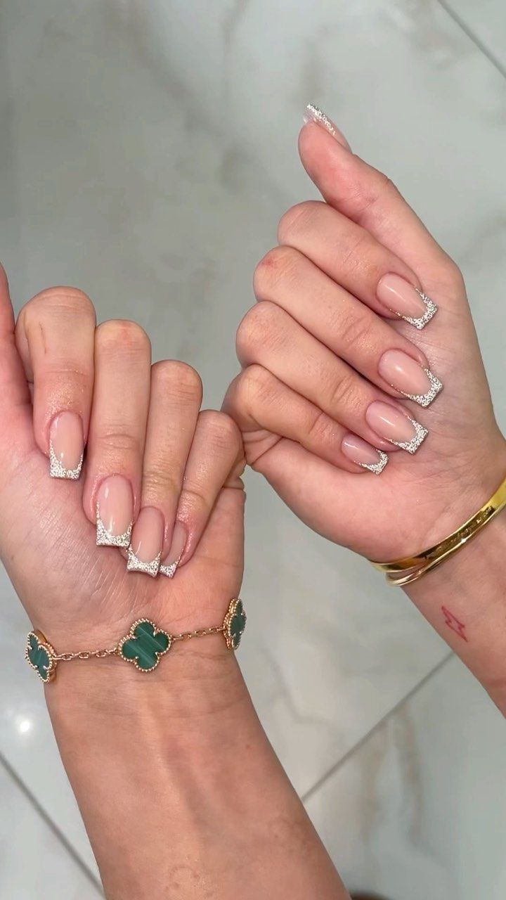 Chic French Manicure: Nude Base with White Tips and Silver Accents.