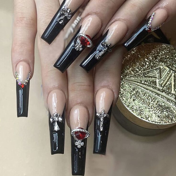 Elegant Black and Nude Nail Design with Elongated Shapes and Chic Embellishments.