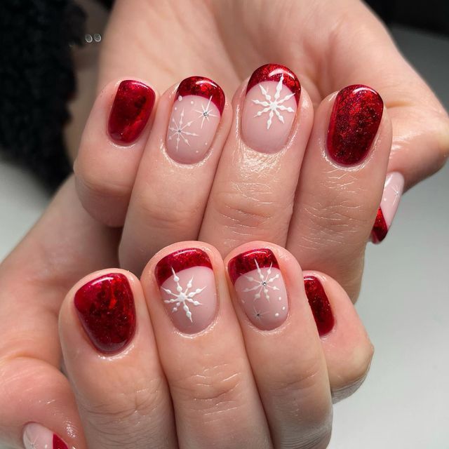 Chic Festive Nail Design with Red Tips and Snowflake Accents.