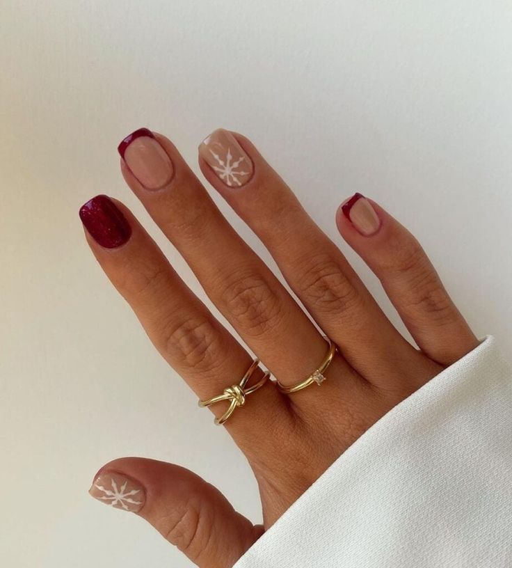 Sophisticated Burgundy and Nude Nail Design with Intricate White Florals and Contrasting Finishes.