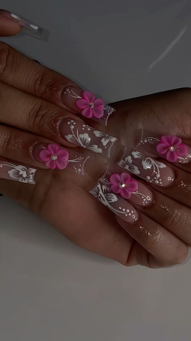 Elegant Floral Nail Design: Three-Dimensional Pink Flowers on a Nude Base with Delicate White Patterns for a Whimsical Spring Look.