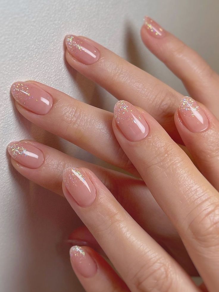 Chic Soft Pink Nail Design with Subtle Glitter Accents for Elegant Occasions.