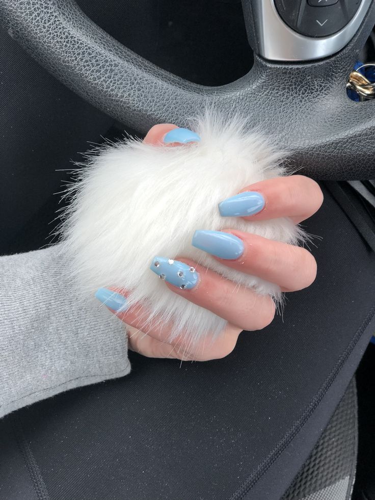 Chic Pastel Blue Nails with Rhinestone Accent and Fluffy Accessory for a Playful Modern Aesthetic.