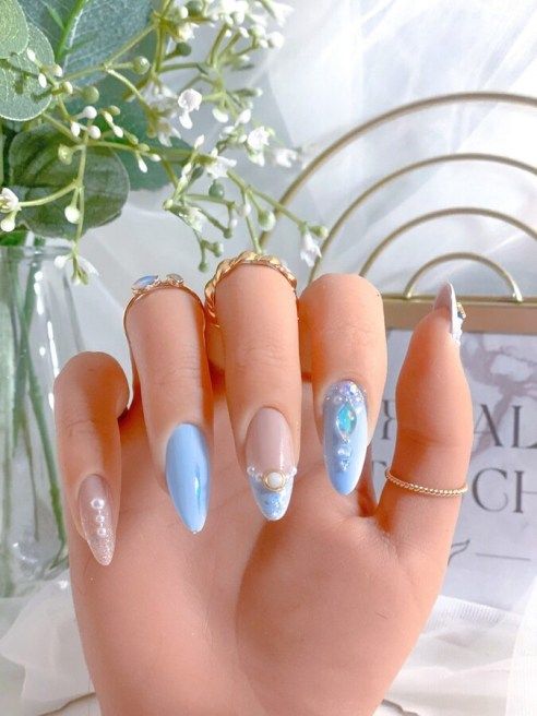 Chic Elegant Nail Design with Soft Blue Shades and Glamorous Embellishments.