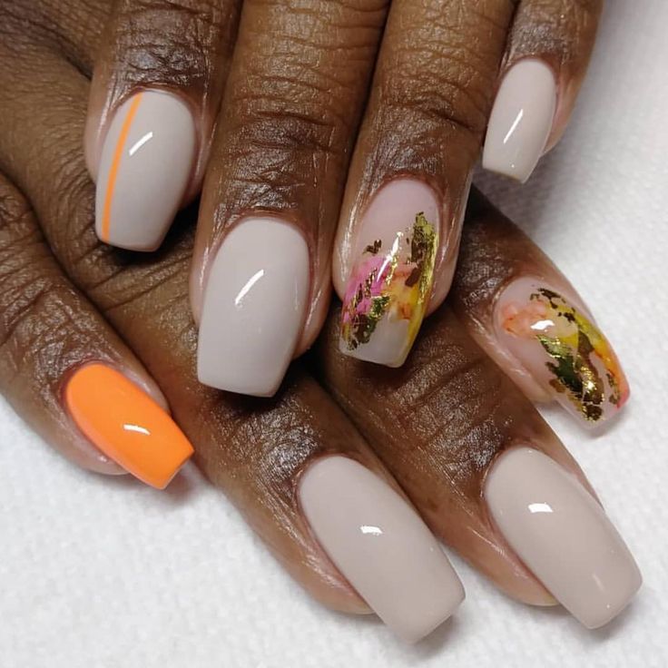 Sophisticated Nail Design: Soft Nude Base with Vibrant Orange Accents and Metallic Floral Details