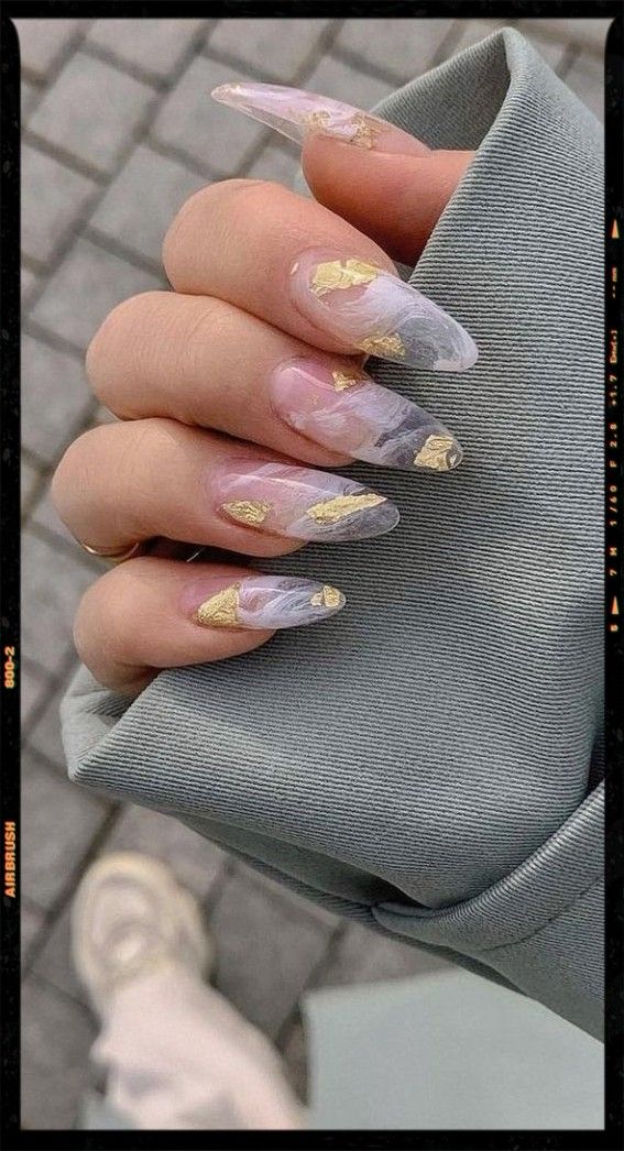 Luxurious Stiletto Nail Design with Translucent White and Gray Shades Accented by Gold Leaf.