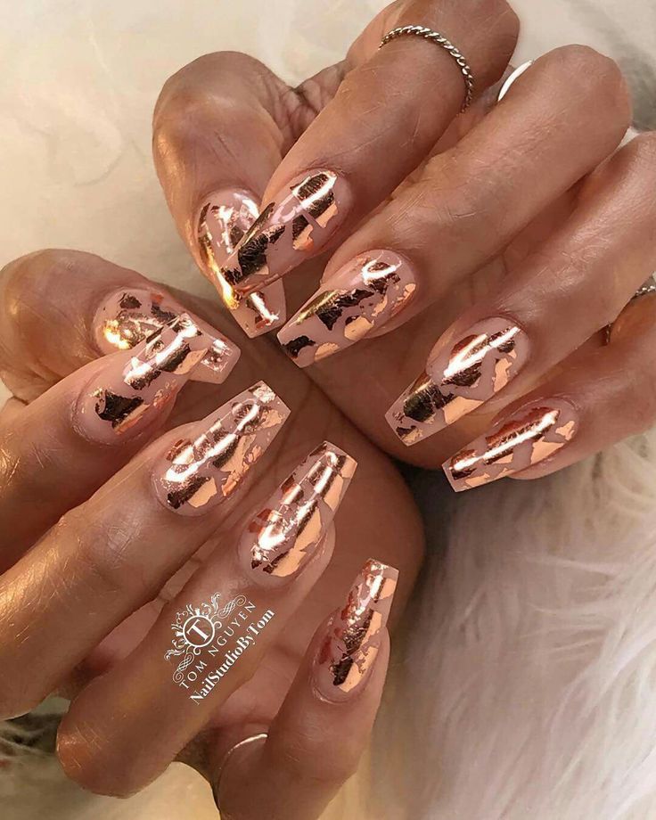 Elegant Rose Gold Coffin Nail Design with Geometric Patterns.