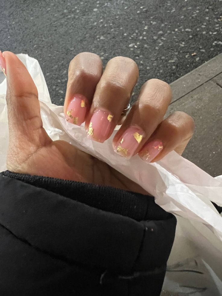 Elegant Soft Pink Nail Design with Golden Flakes for Sophisticated Occasions.