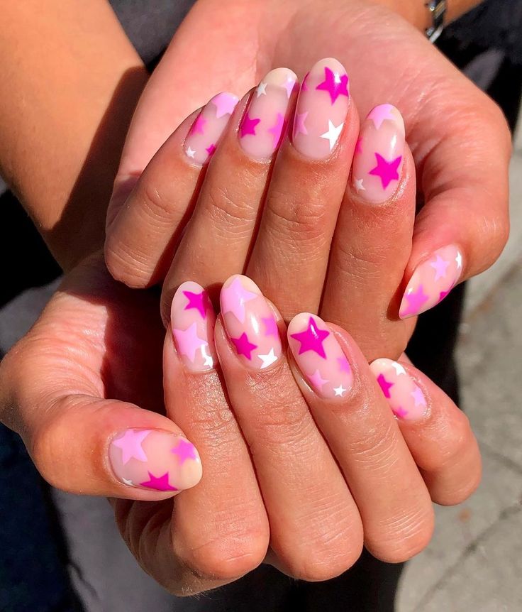 Playful Soft Pink and Nude Nail Design with Vibrant Stars for a Chic Statement.