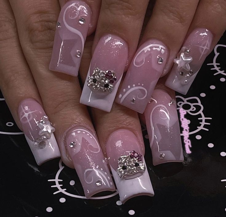 Chic Pink and White Nail Design with Intricate Swirls and Sparkling Gemstones