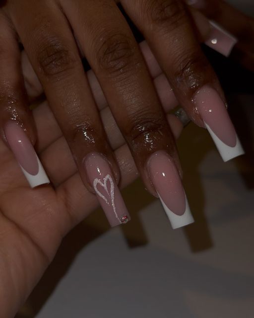 Chic Modern Nail Design: Soft Pink Base with Elegant White Tips and Romantic Heart Accents.