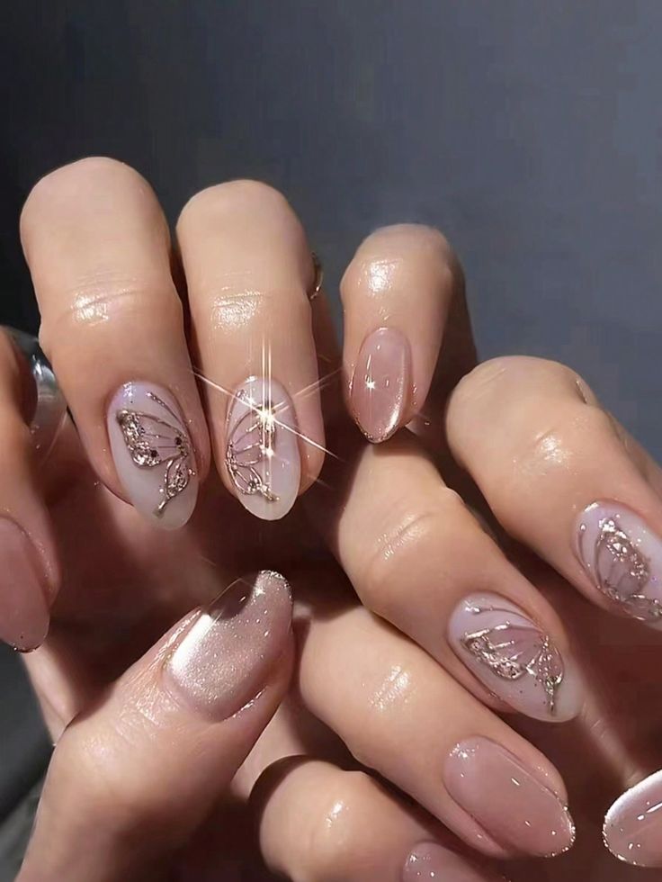 Elegant Delicate Nail Art with Muted Pink Tones and Sparkling Butterfly Designs.