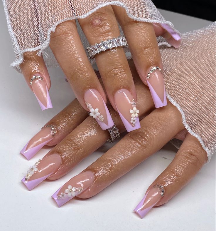 Sophisticated Nude and Lavender Nail Design with Pearl and Rhinestone Accents.