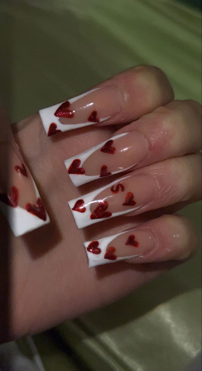 Charming Nail Design: White Tips with Glittery Red Hearts for a Playful, Romantic Look.