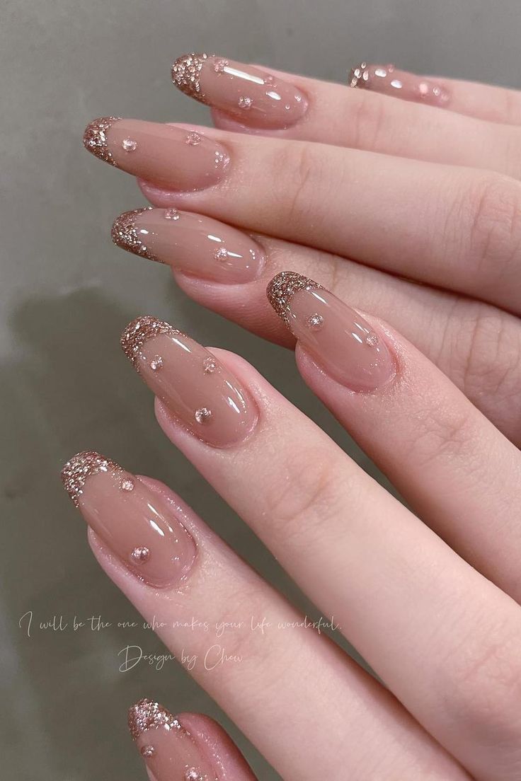 Elegant Nude Nail Design with Golden Tips and Gemstone Accents.