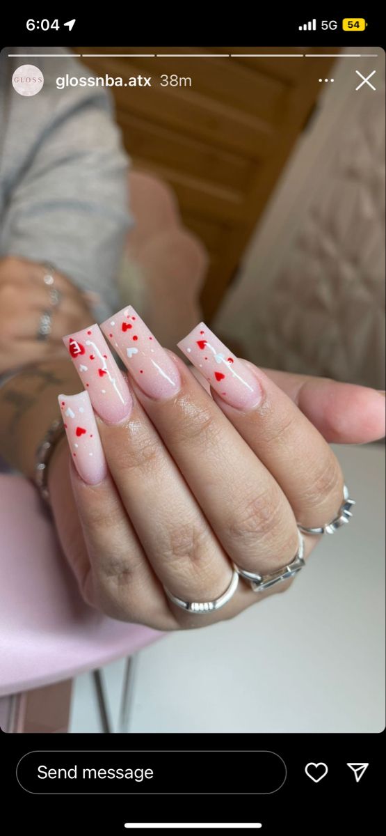 Charming Soft Pink Nail Design with Playful Red Heart Accents for a Flirty Aesthetic.