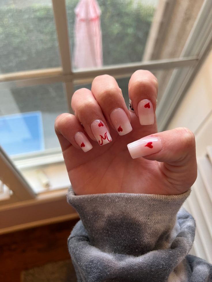 Charming Romantic Nail Design: Classic White with Playful Red Hearts and Swirls