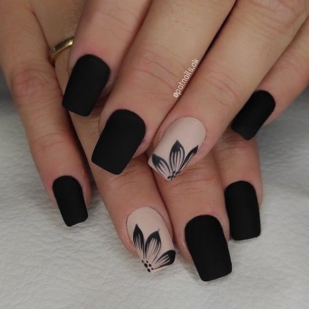 Sophisticated Matte Black and Soft Nude Nail Design with Floral Accents.