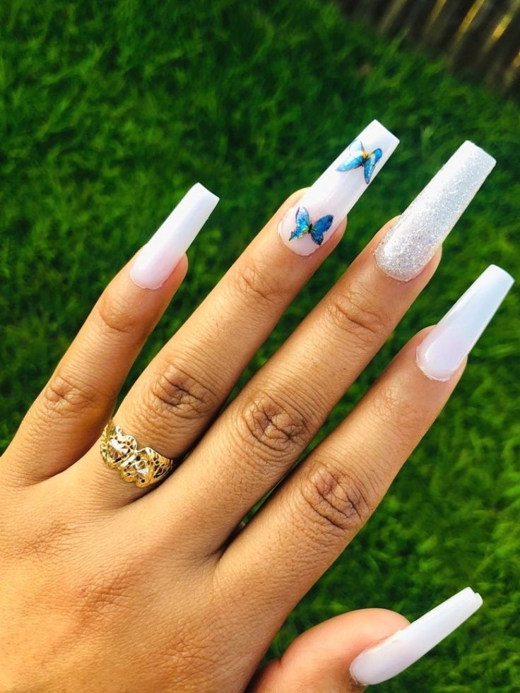 Chic White Tip Nail Design with Metallic Shimmer and Whimsical Butterfly Accent.